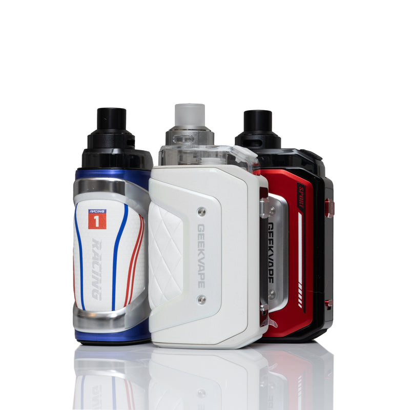 Three Geekvape vape devices standing upright on a reflective white surface against a white background. The left device is white with blue and red racing stripes and a blue top.